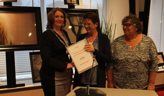 Lida Leenen en Paula Kruit overhandigen handtekeningen voor een supermarkt in de Postwijk aan burgemeester Carla Breuer. | Foto: archief/ Nico Kuyt