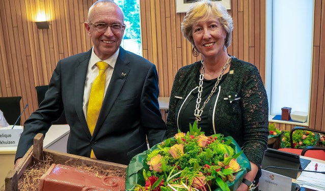 Kees Wassenaar kreeg behalve de Zilveren Speld ook bloemen en een echte Leiderdorpse dakpan van burgemeester Driessen. | Foto: J.P. Kranenburg