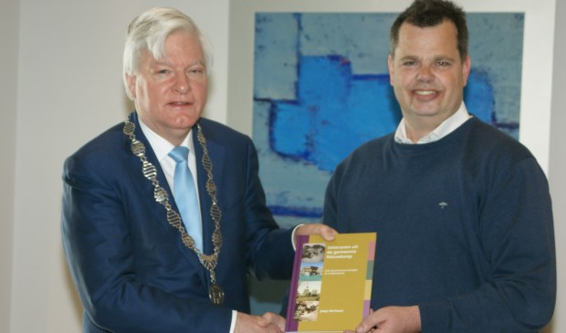 Het eerste exemplaar van het 'Veteranenboek Nieuwkoop' overhandigde Derksen aan burgemeester Buijserd.