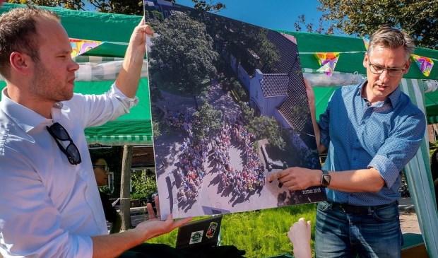 Interim schoolleider Freek van der Brugge (links) en de nieuwe directeur Maarten Meijers tonen de jubileumfoto.