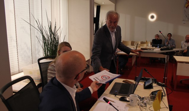 De heer Boer overhandigt namens een groep bewoners een pakket handtekeningen aan de voorzitter van de commissie, Frans Nederstigt. | Foto: NK