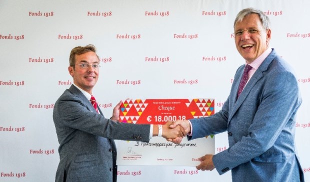 Cornelis Visser (rechts) ontvangt de cheque uit handen van Fonds 1818-directeur Sanne ten Bokkel Huinink.