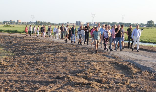 Een deel van de bezoekers wandelt over het toekomstig fietspad door de Boterhuispolder. | Foto: Nico Kuyt