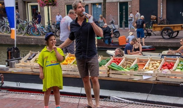 Plastic Soup Surfer Merijn Tinga als veilingmeester, met als hulpje een van de kinderen van Stichting Nadja.