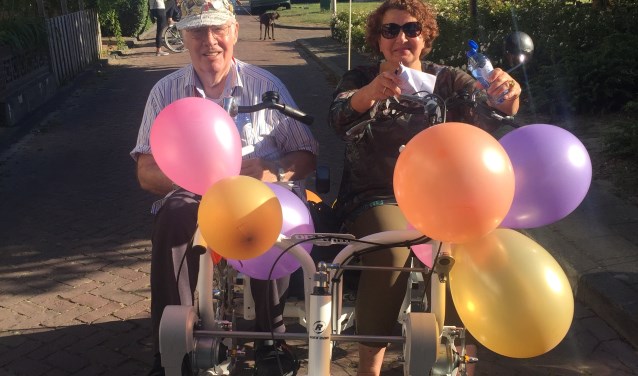 Locatiemanager Rianne de Mooij fietsend met Vlietstede bewoner de heer Glasbergen.