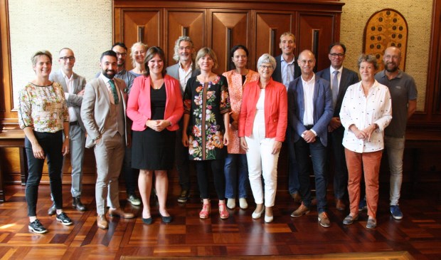De ondertekenaars bij elkaar in de B&W kamer van het Leidse stadhuis. Derde van links vooraan (met roze jasje) staat wethouder Angelique Beekhuizen.