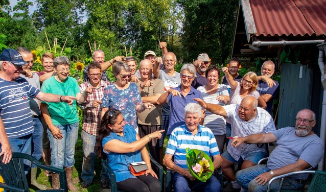 Zittend met de bloemen Gerard van Velzen, met om hem heen een aantal vrijwilligers van de schooltuinen. | Foto: J.P. Kranenburg