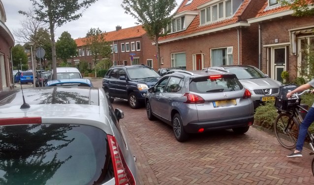Twee elkaar tegemoet rijdende auto's kunnen elkaar in de straat niet passeren. Wie gaat er achteruit? En lukt dat zonder spiegels van andere auto's eraf te rijden? Deze situatie is veel bewoners een doorn in het oog. Ze willen dat hun straat eenrichtingsverkeer wordt.