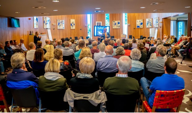 Wethouder Willem Joosten spreekt de eerste groep van ruim 150 bewoners toe. Links staat Maya van der Steenhoven van het programmabureau Warmte Koude Zuid-Holland.