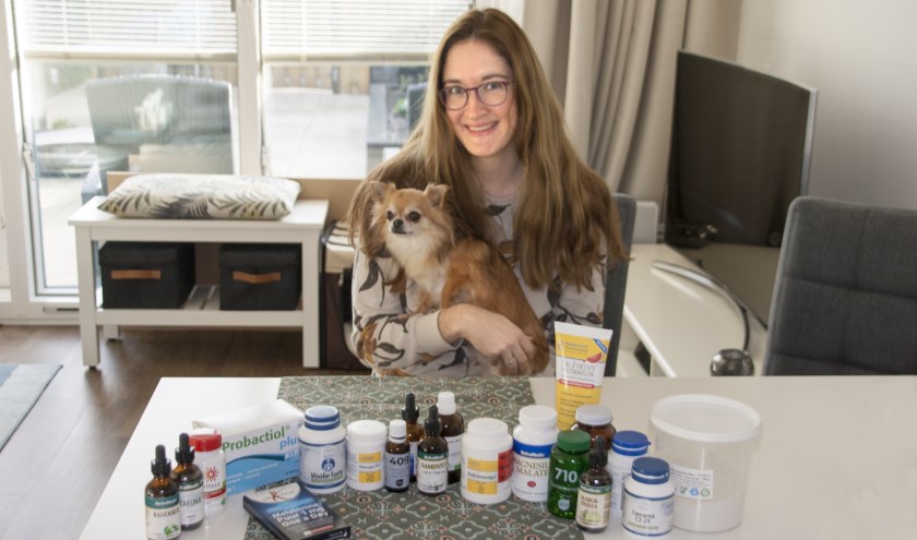 Mariëlle met haar hondje Benthe, te midden van alle supplementen die ze nodig heeft.