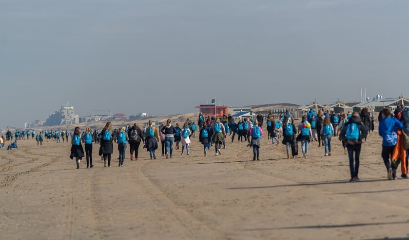 De kinderen wandelen deels over strand.