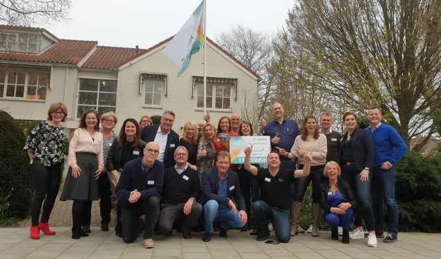 Trotse gezichten bij de deelnemers. Annelies Osinga (met bord) en voorzitter Arthur van Dijk (rechts) zijn blij met het enorme bedrag.