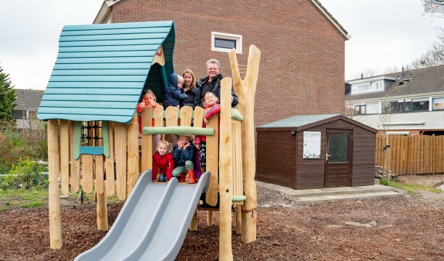Bestuursleden Jeanine van Jaarsveld en Albert Verkuyl van buurtverenigingen Op Dreef met een aantal buurtkinderen op het nieuwe speelhuisje. | Foto: J.P. Kranenburg