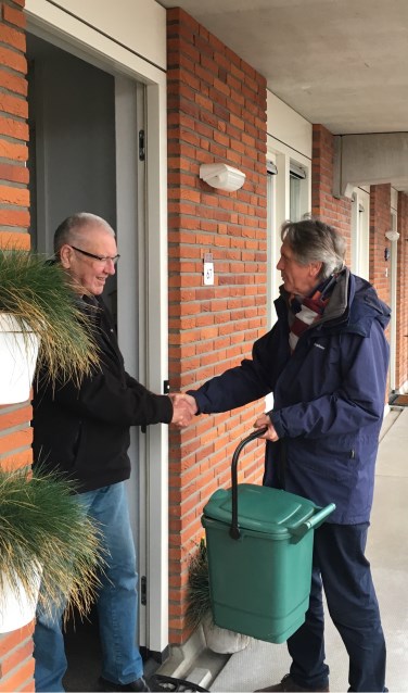 De voorzitter van de VVE neemt het eerste GF-containertje in ontvangst