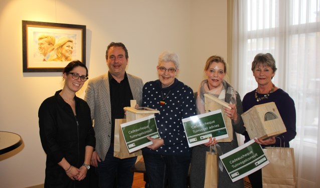 Wethouder Jan van Rijn met rechts naast zich de trotse winnaars van de vogelfotowedstrijd.