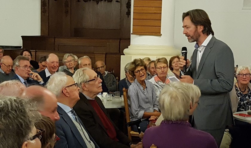 Moderator Huibrecht Bos tijdens een eerder debat in gesprek met een deelnemer.