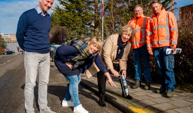 Burgemeester Driessen verft een stukje stoeprand geel met aanwijzingen van lerares Adinda Dernison. Links locatieleider Ben Kottenhagen van het PC Hooft College. | Foto: J.P. Kranenburg