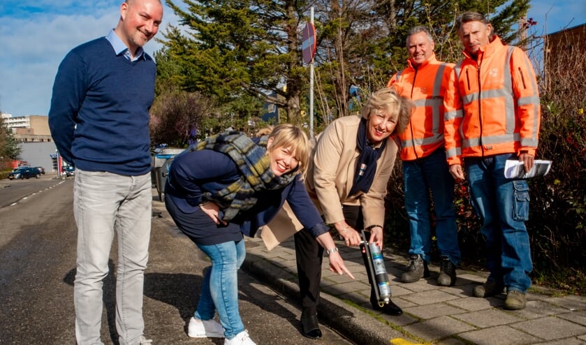 Burgemeester Driessen verft een stukje stoeprand geel met aanwijzingen van lerares Adinda Dernison. Links locatieleider Ben Kottenhagen van het PC Hooft College. | Foto: J.P. Kranenburg
