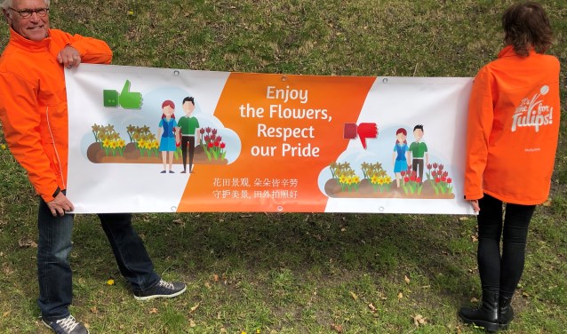 Deze banner vraagt de toeristen om respectvol genieten van de bollenvelden. | Foto: PR