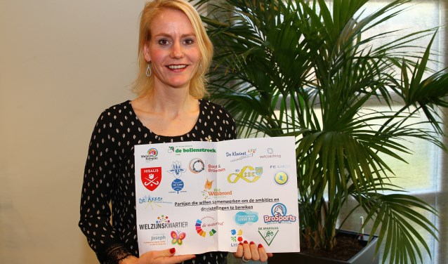 Wethouder Van der Laan met de deelnemerslijst van sport- en beweegaanbieders.