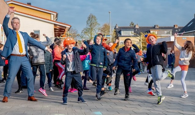 Op KBS De Schakel werden de Koningsspelen geopend met het dansen en zingen van de Pasapas. Ook wethouder Willem Joosten van onderwijs en sport (geheel links) deed mee.