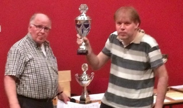 Internationale schaakmeester Fred Slingerland neemt uit handen van wedstrijdleider Cok Ippel de beker in ontvangst.