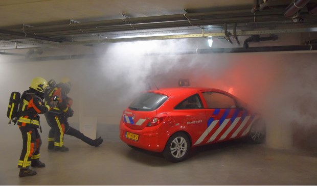 De brandweer redt een 'slachtoffer' bij de brandweeroefening in de parkeergarage van De Ommedijk.