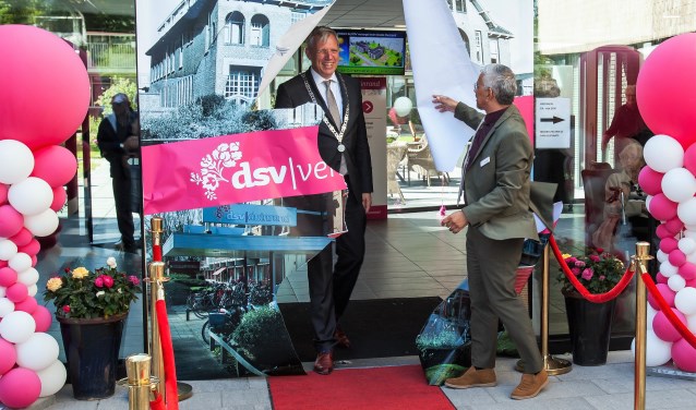 Burgemeester Cornelis Visser loopt door een afbeelden van het oude Gast- en Weeshuis, een voorganger van de Duinrand.