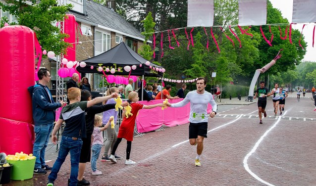 Kinderen staan klaar met sponzen voor de lopers op de Splinterlaan.
