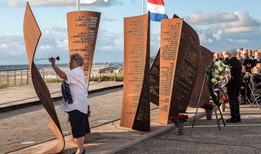 Nabestaande Lies van Beelen steekt een roos in het monument.