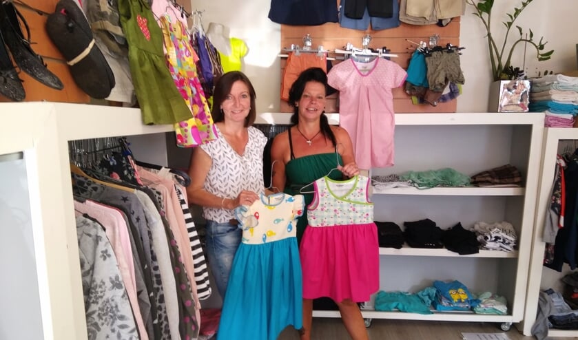 Barbara van Abswoude (rechts), vrijwilliger bij de Kledingbank Leiden neemt de jurkjes in ontvangst van Liz Wassenaar van de Prince/Princess Foundation.