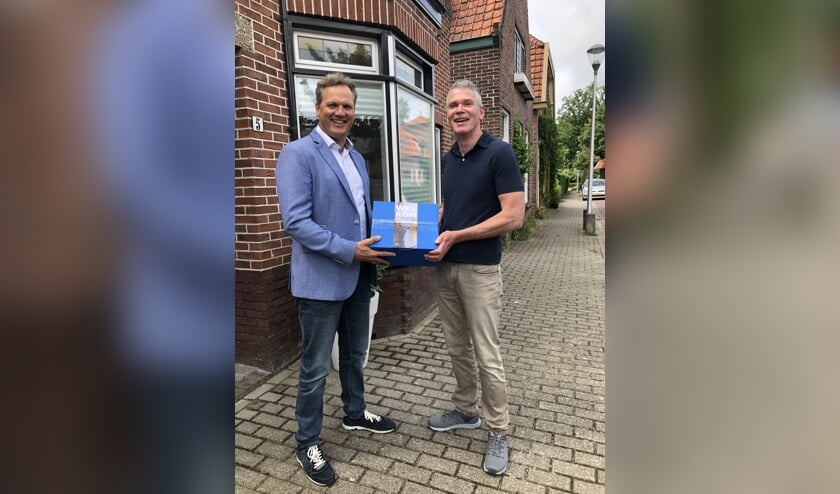 Arjan Heijl overhandigt het eerste welkomstpakket aan Erik van Gogh. Hij woont sinds juni in de Warmundastraat.| Foto: pr.