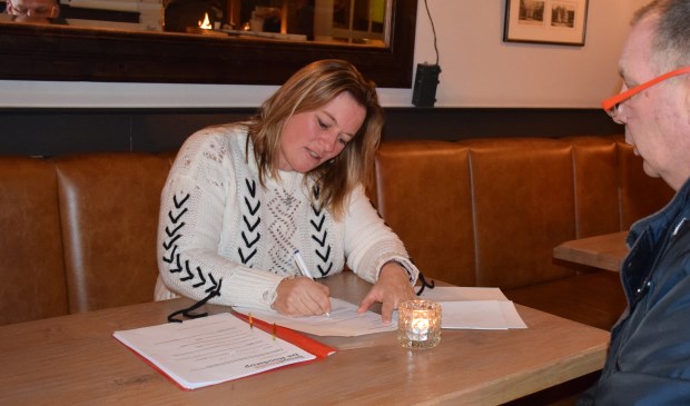 Sandra Konings, van autorijschool Konings in Apeldoorn, is voorzitter van het broodfonds. Hier tekent zij een van de contracten.