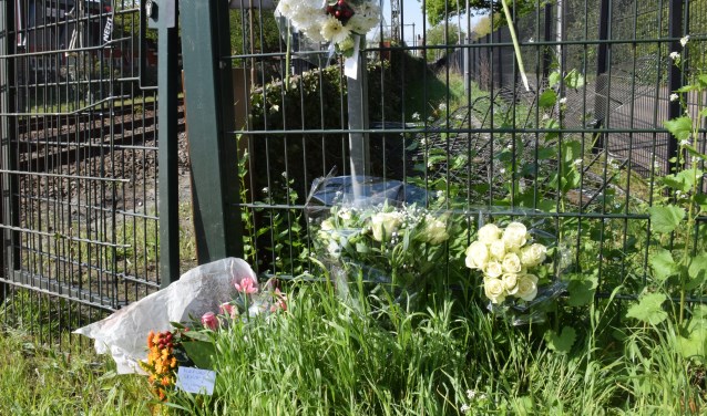 Op de spoorwegovergang hebben verschillende mensen bloemen gelegd als eerbetoon aan Henk Reinink.