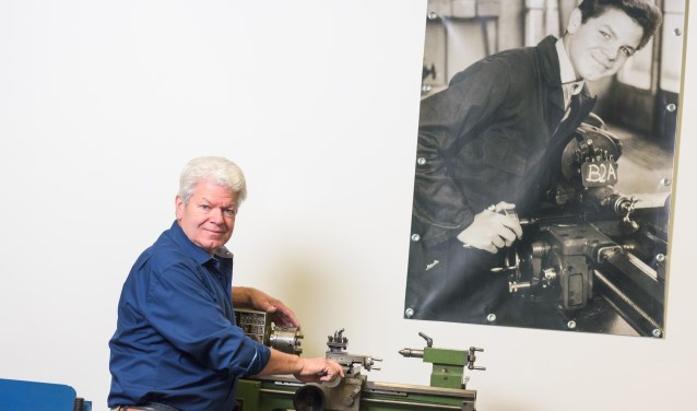 Wim van Roy in zijn atelier bij een draaibank waar hij op de foto achter hem als jongen van 12 jaar voor het eerst kennis maakte met zijn vak