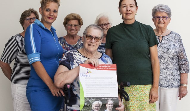 Susanne (tweede van links) en Anita (tweede van rechts) samen met een aantal bezoekers en vrijwilligers van de huiskamers. Foto: Michel van de Langenberg.