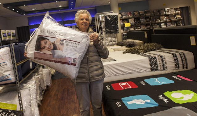 Een tevreden klant toont haar net gekochte kussen in de showroom. Foto: Michel van de Langenberg