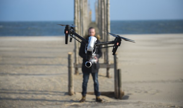 Gerhard Smit met een drone waar een camera aan hangt.