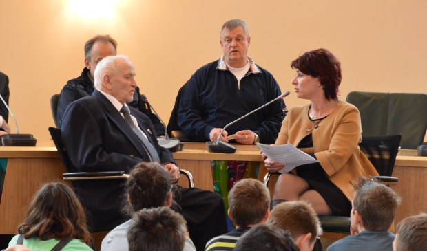 Salomon Valvekens in gesprek met Monique van Gaalen van het 4 en 5 mei Comité Texel. Leerlingen luisteren.