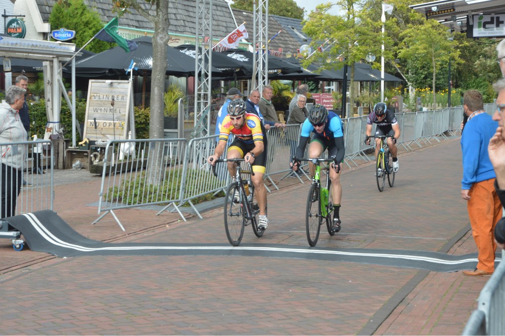 Vriend en Huijsman (rechts) naast elkaar over de finish in de één na laatste ronde. Achter hen een achterblijver.
