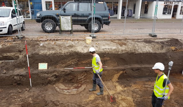 Een medewerker van Arceologie West-Friesland kijkt naar de restanten van de plaggenput.