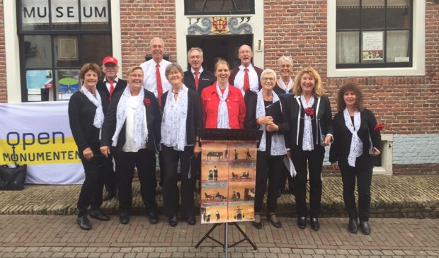 Het koor Chante Majeur met de smartlap ‘De lotgevallen van Kees’ op de stoep van de Oudheidkamer