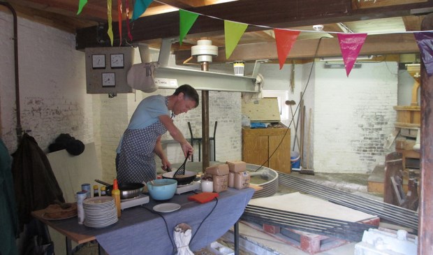 Vrijwilliger Hans Smallenbroek bakt pannenkoeken.