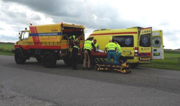 Het slachtoffer wordt van het kusthulpverleningsvoertuig overgedragen naar de ambulance.