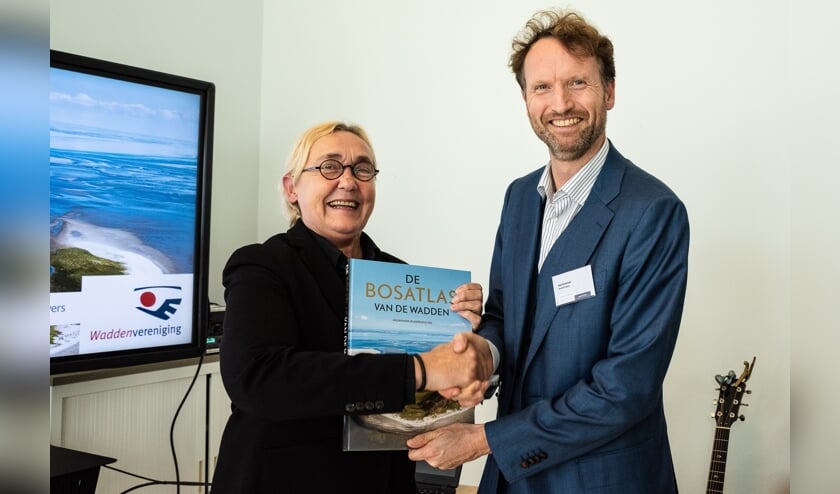 Lutz Jacobi neemt het eerste exemplaar van de Bosatlas van de Wadden in ontvangst.