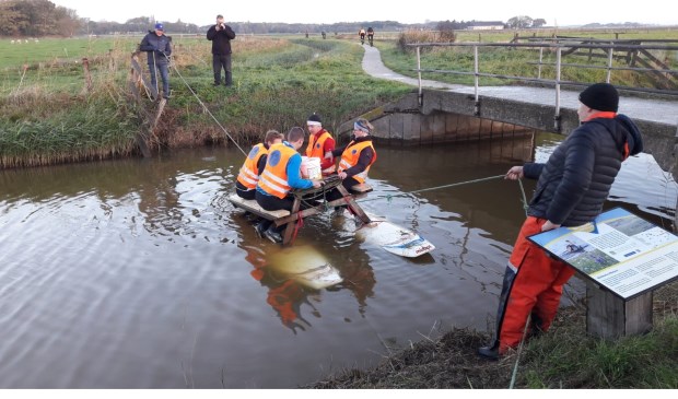 Emmers water vullen, zittend op een picknicktafel op het water.