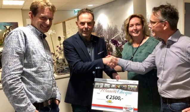 Menno en Corina Schuijl overhandigen de cheque aan Ingmar Veeger en Jan Klok van het Tesselhuus.