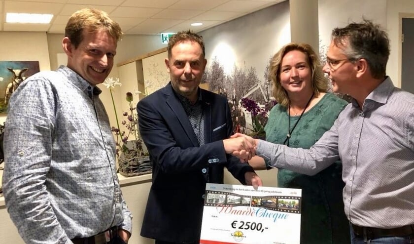 Menno en Corina Schuijl overhandigen de cheque aan Ingmar Veeger en Jan Klok van het Tesselhuus.