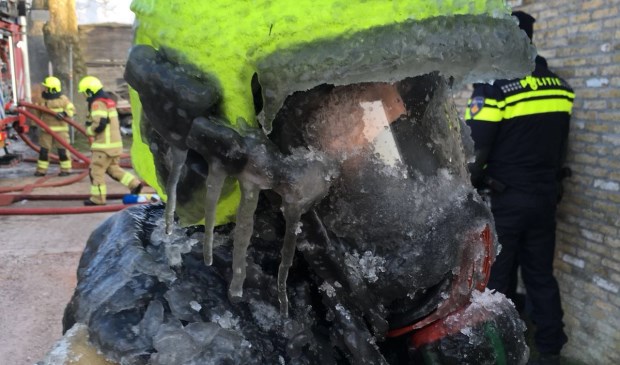 IJspegels aan de helm van de brandweer na het blussen in Oosterend.