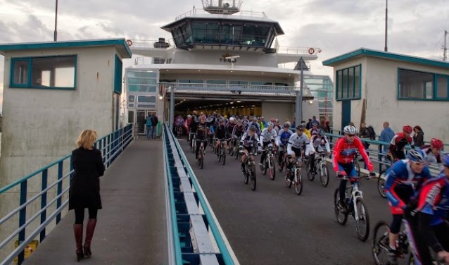 Fietsers komen van de boot af.